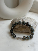 Elly’s 9.8-11.5mm 15pcs Tahitian Ocean peacock black hunter Pearls Bracelet: Extreme luster mirrored, 8.1” knotted. Pearl jewelry idea.