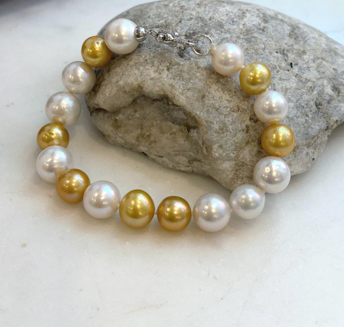 Elly’s 17pcs 10.2-11.5mm White golden Edison Pearls Bracelet: Extreme luster mirrored, 8.3” knotted, S925 silver Bracelet.