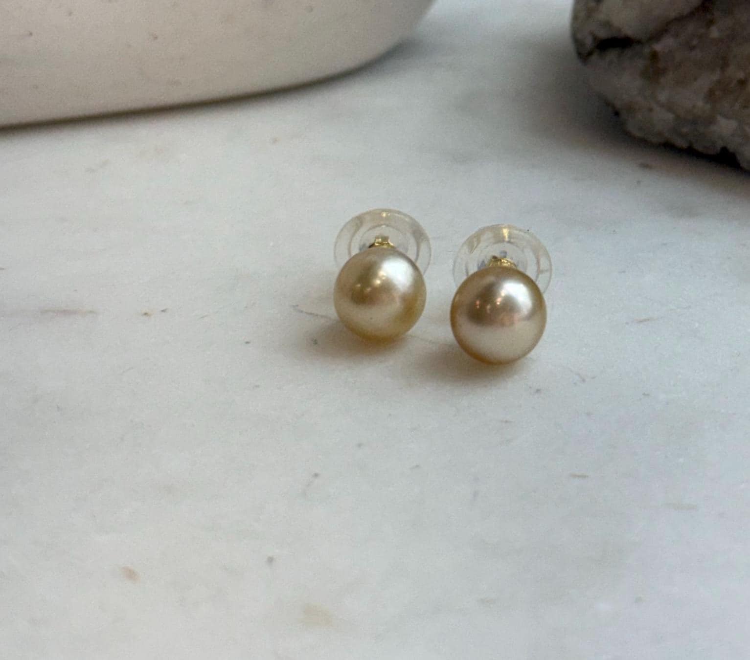 Elegant natural gold pearl earrings with brilliant mirror luster.