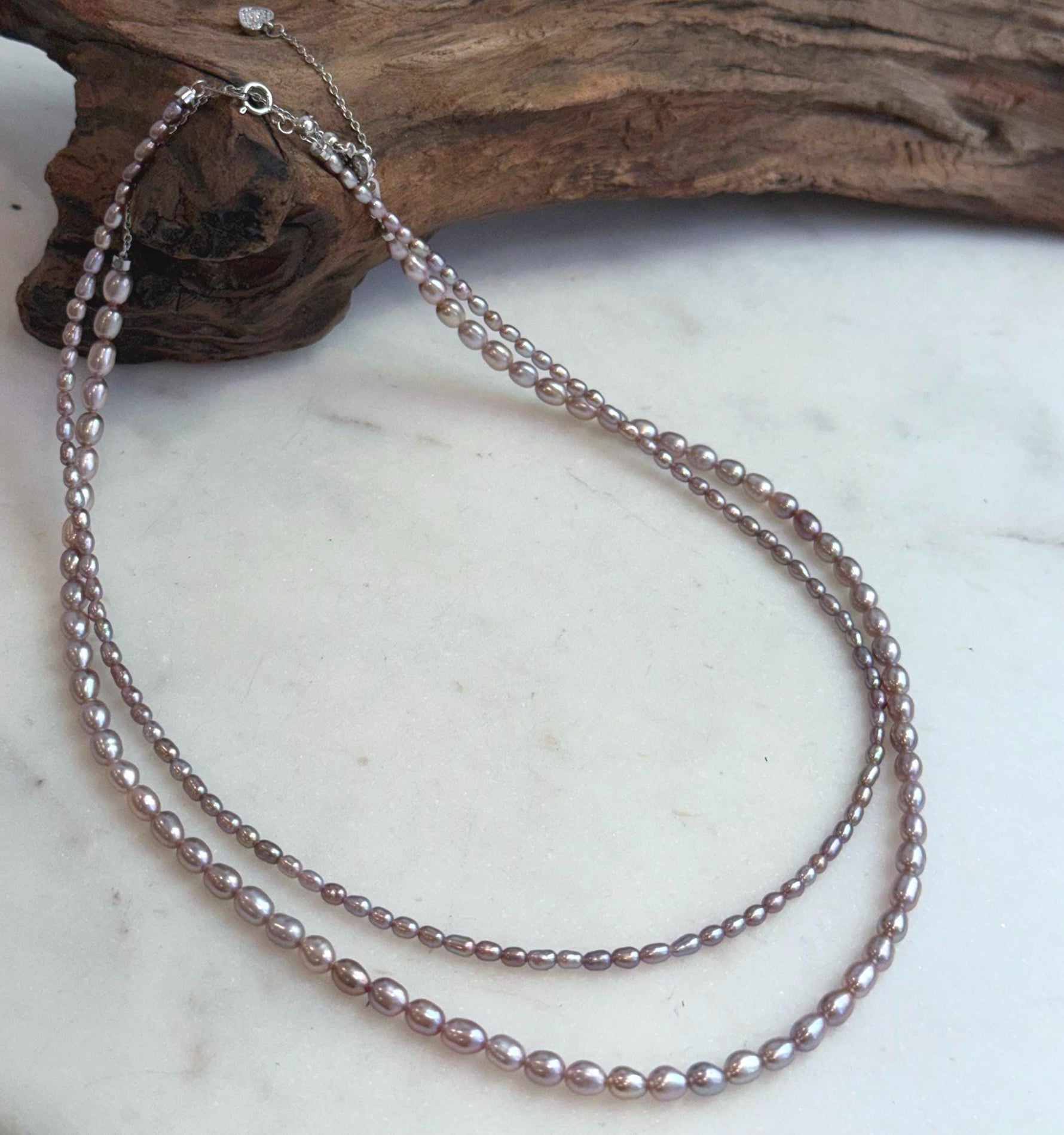Double strand oval pearl necklace in metallic rose color.