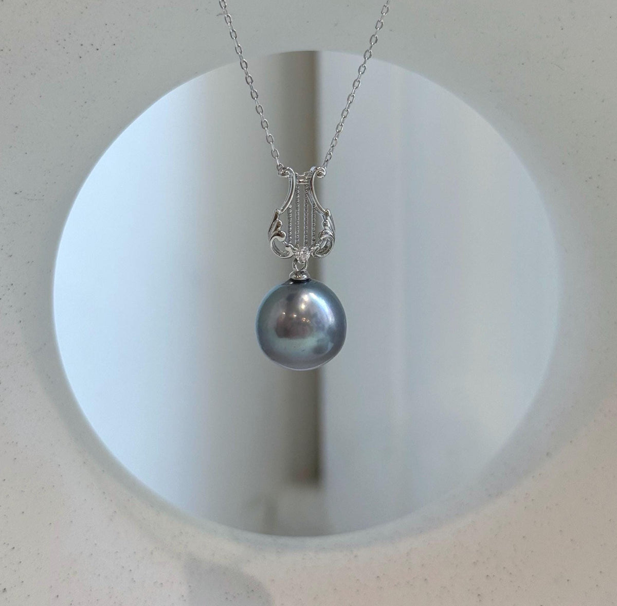 Luxury Tahitian pearl pendant with iridescent platinum pearl and sterling silver setting.