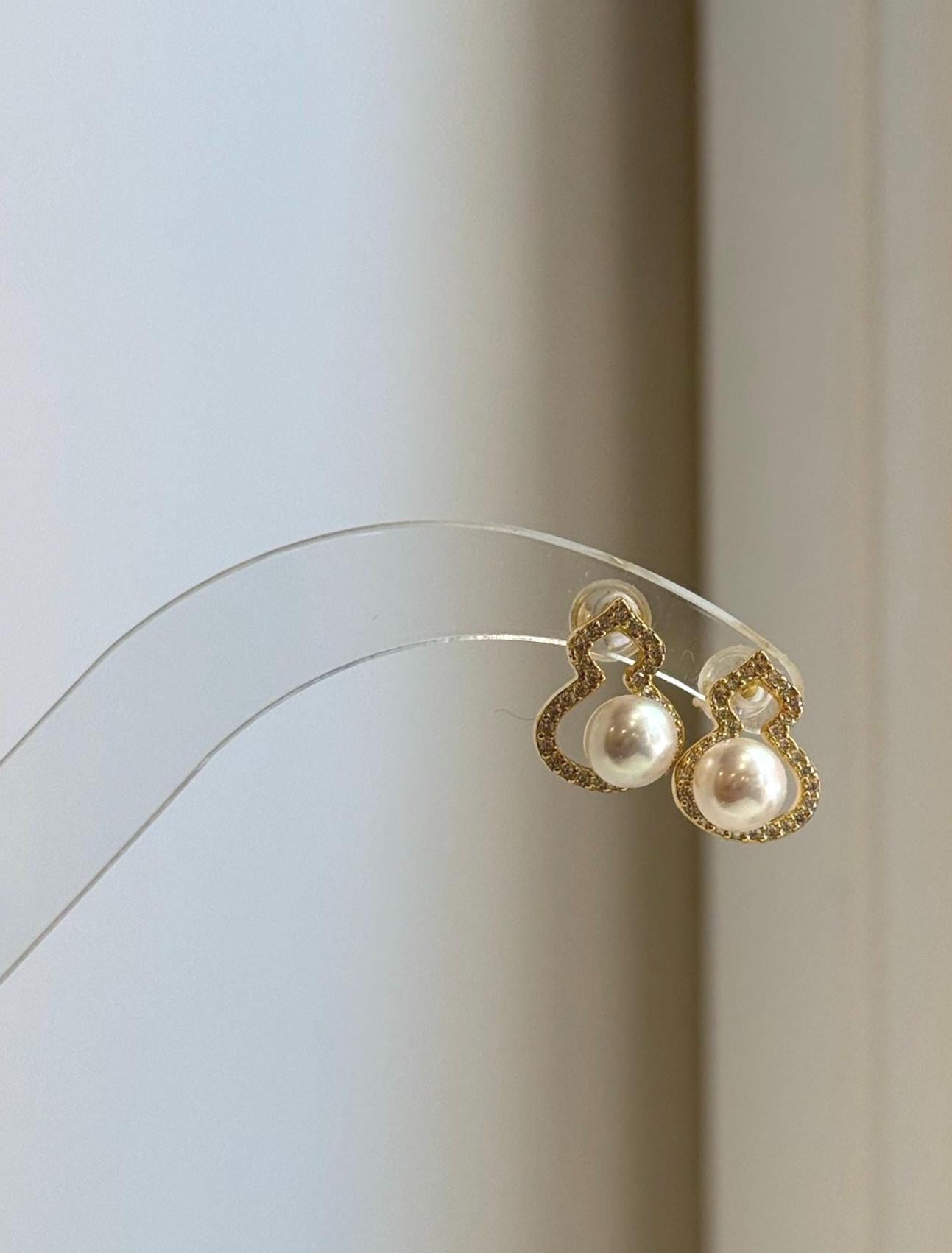 Genuine off white freshwater pearl stud earrings featuring natural gourd-shaped pearls and sterling silver.