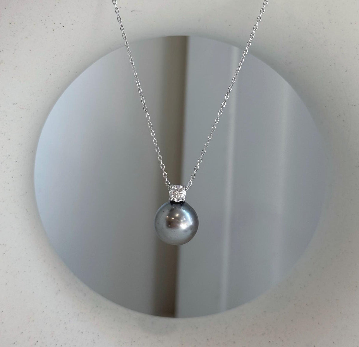 Luxury Tahitian pearl pendant featuring sparkling moissanite accent.