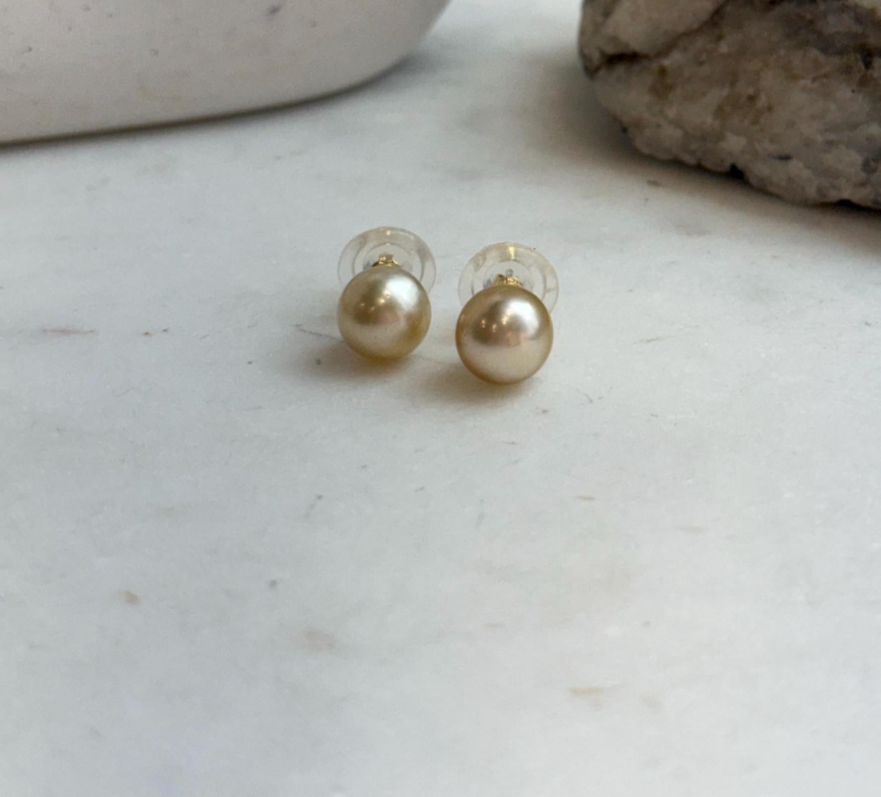 Minimalist deep gold pearl stud earrings with exceptional mirror shine.