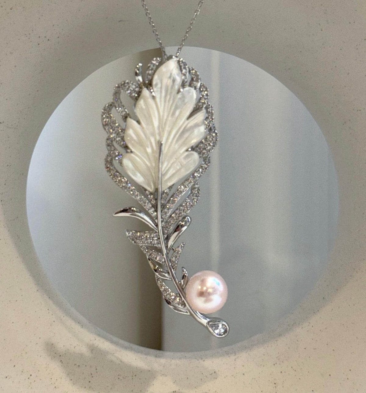 Convertible 2-in-1 pearl jewelry worn as both a brooch and pendant necklace.