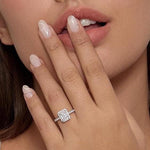 Halo emerald cut moissanite ring on finger.