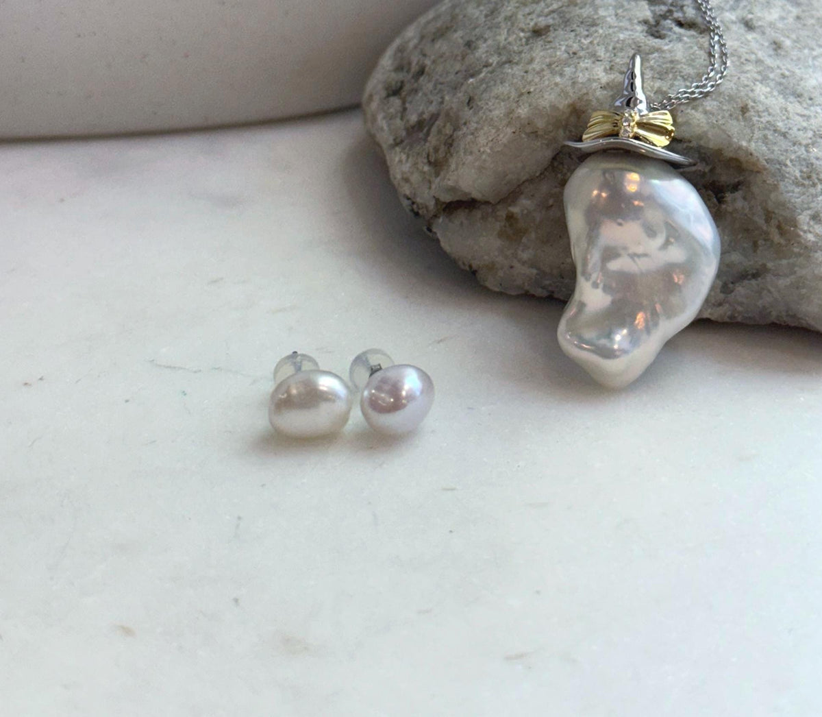Elegant freshwater baroque pearl jewelry set featuring a statement pendant necklace and classic pearl stud earrings.