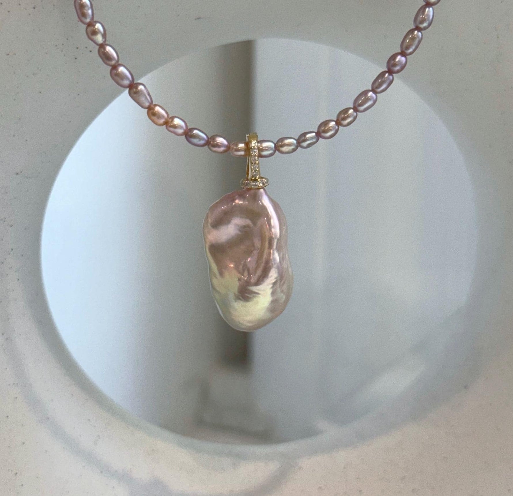 Baroque pearl pendant with delicate pink rose pearl strand necklace.