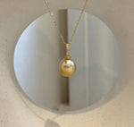Close-up of an 11.2mm golden pearl showing rich natural color and reflective surface.