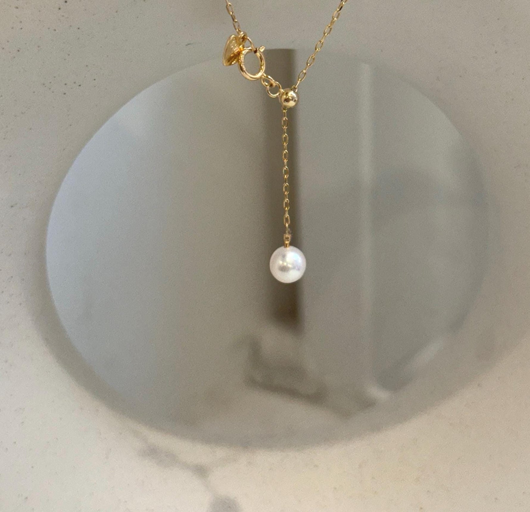 Minimalist pearl lariat necklace featuring South Sea golden and freshwater white pearls.