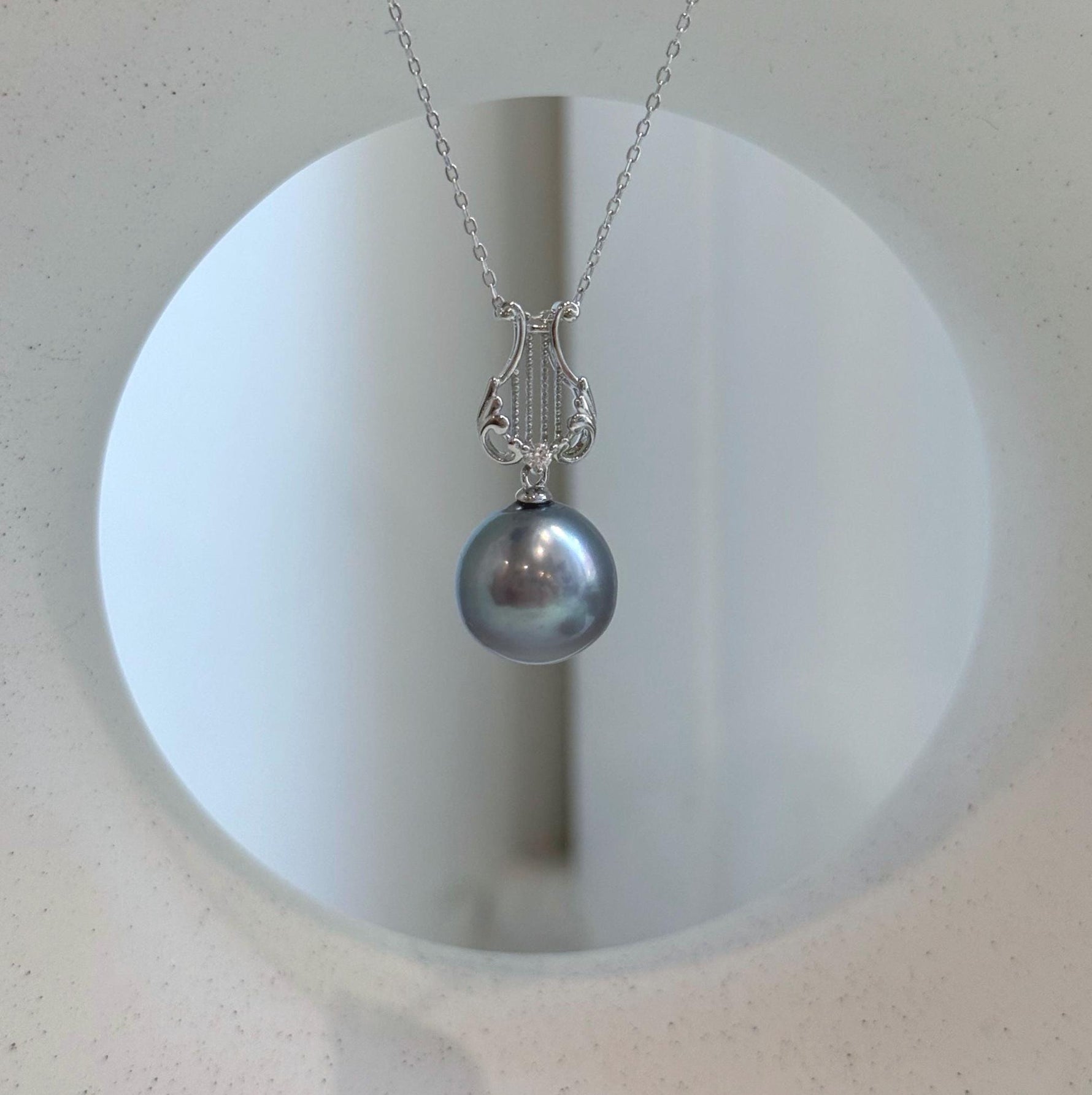 Platinum gray Tahitian pearl necklace with green-blue overtones and sterling silver chain.