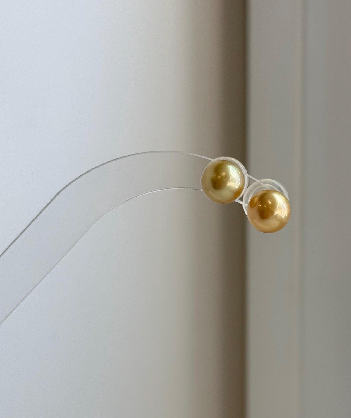 Minimalist South Sea pearl earrings featuring rich deep gold color