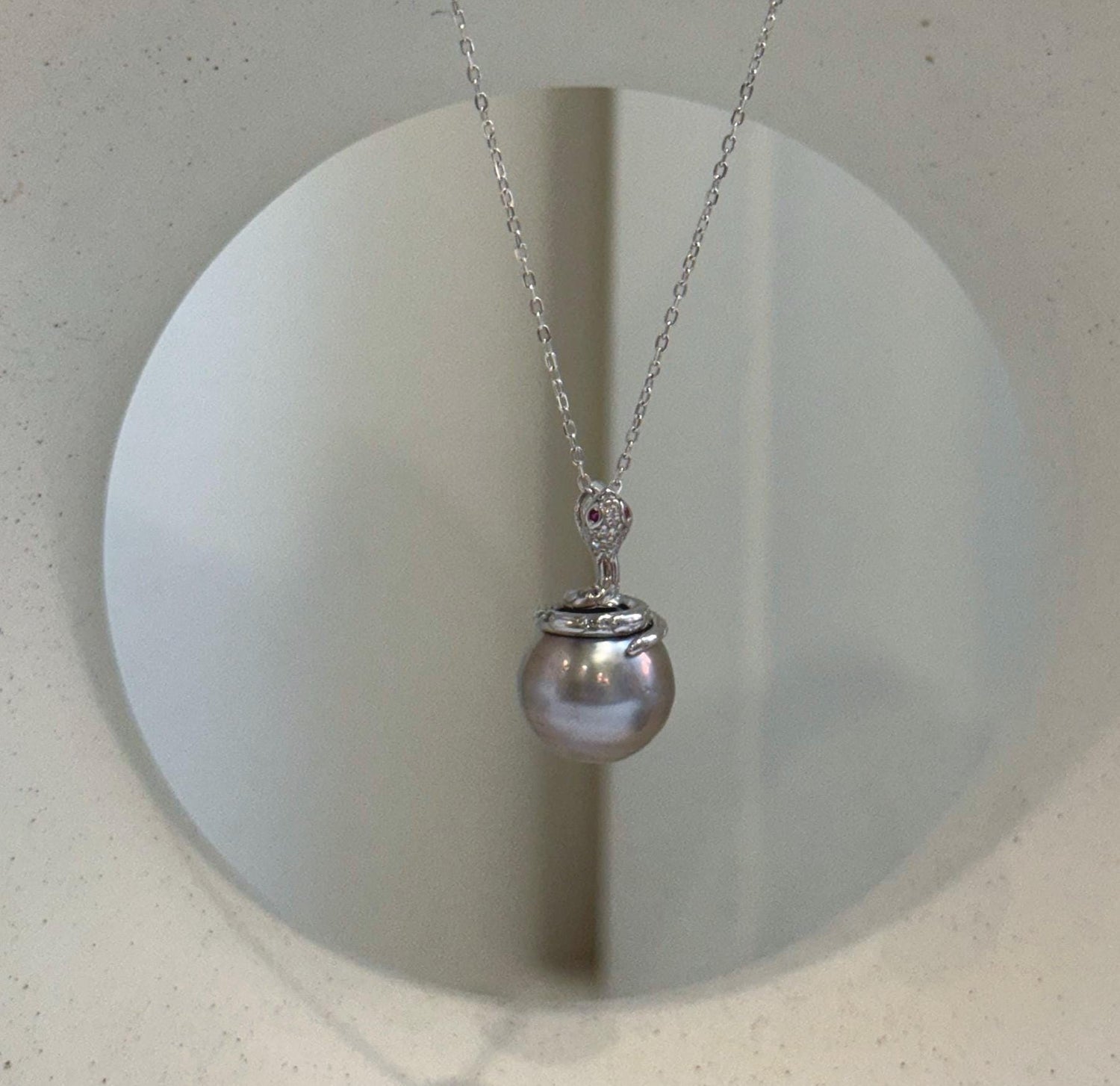 Elly’s 11.8mm Tahitian platinum pearl snake pendant with extreme mirror luster and S925 sterling silver setting.