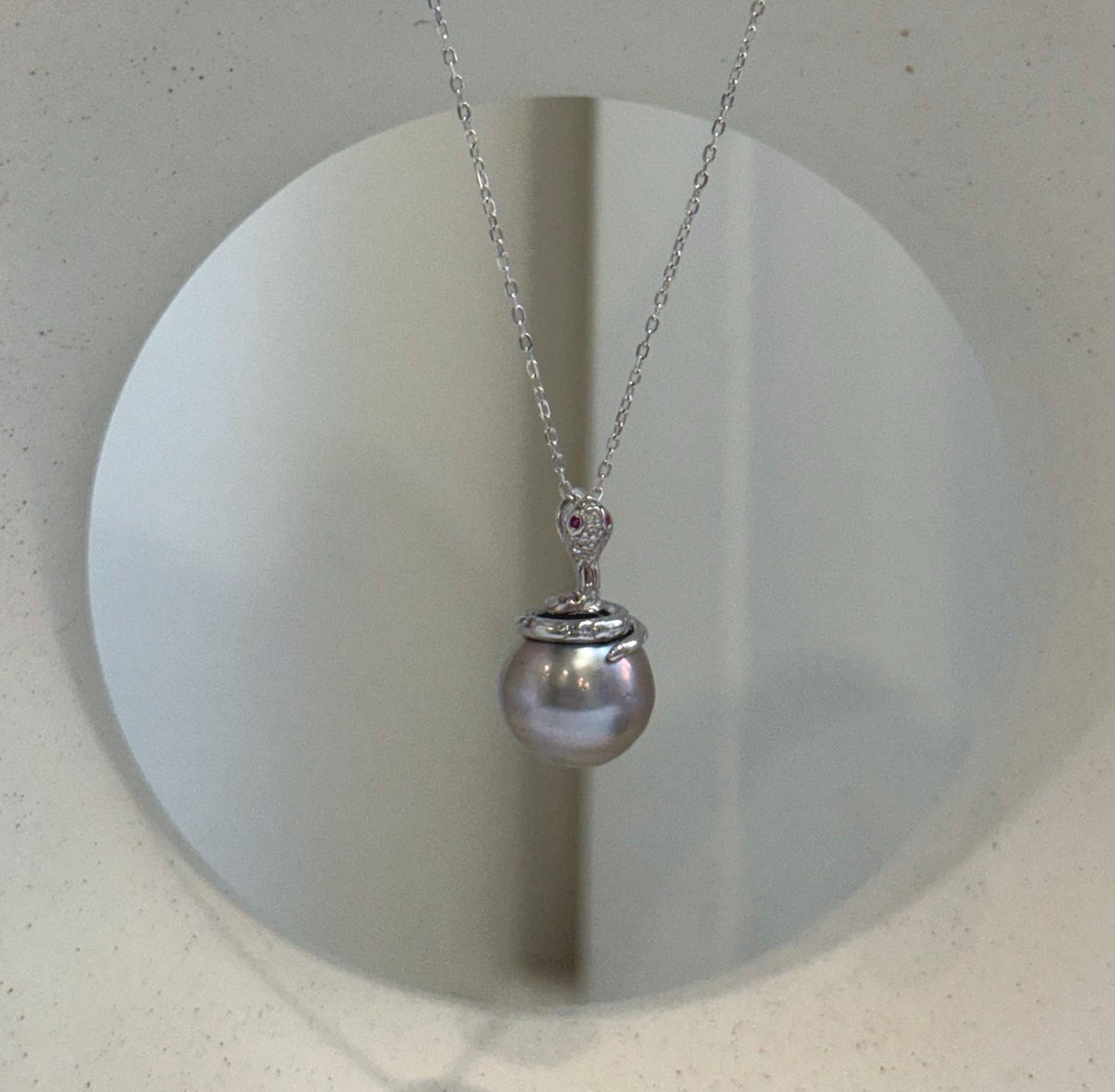 Luxury Tahitian platinum pearl necklace pendant featuring extreme luster and a modern snake design.