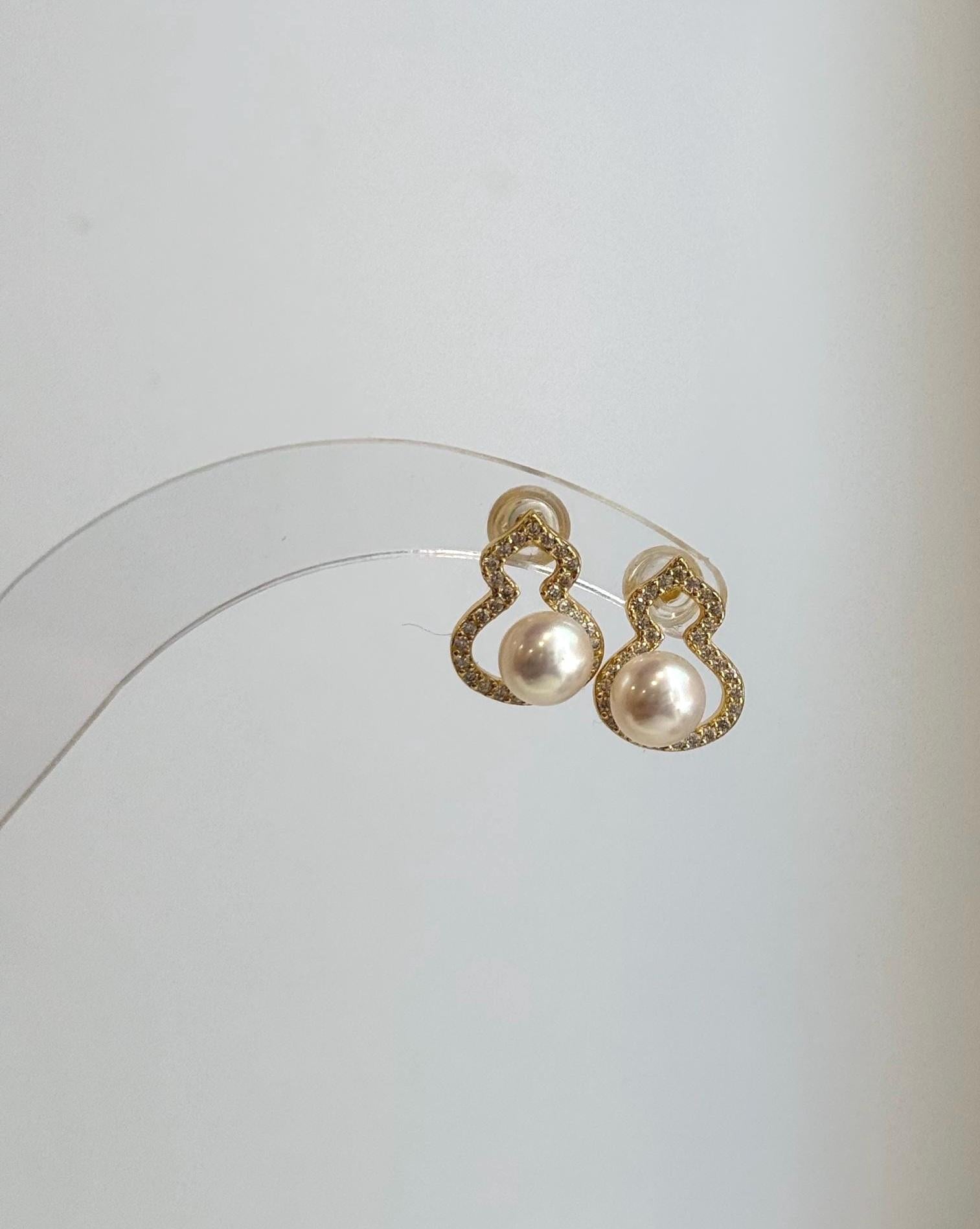 Genuine freshwater pearl gourd earrings displayed in soft natural lighting.