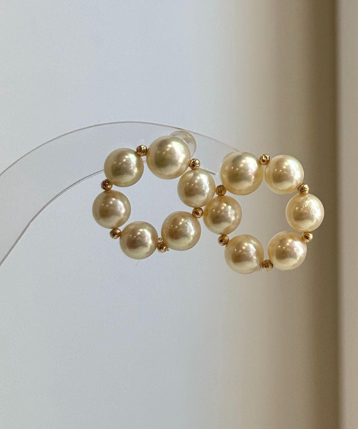 Luxury Japanese Akoya pearl earrings with smooth round donut pearls and polished 18K gold settings.