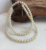Genuine freshwater pearl necklace featuring elegant golden and silver pearl tones.