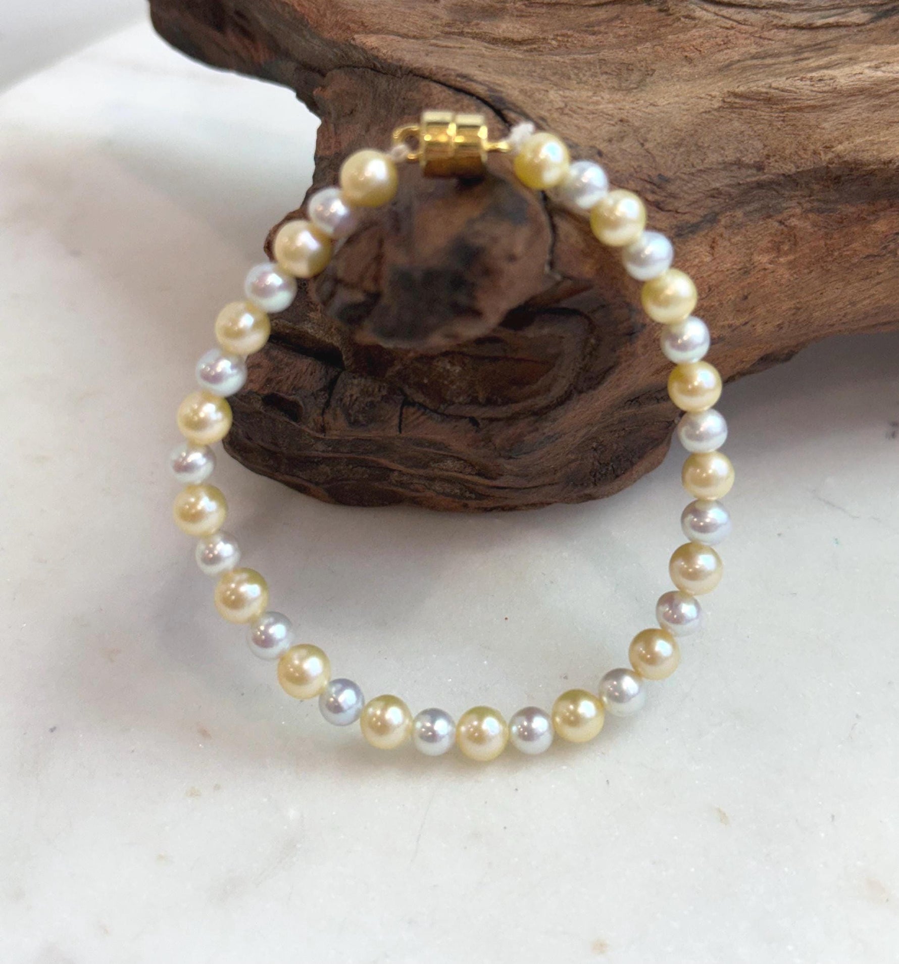 Dainty 4.3–5.5mm pearl bracelet with warm golden and silvery tones.