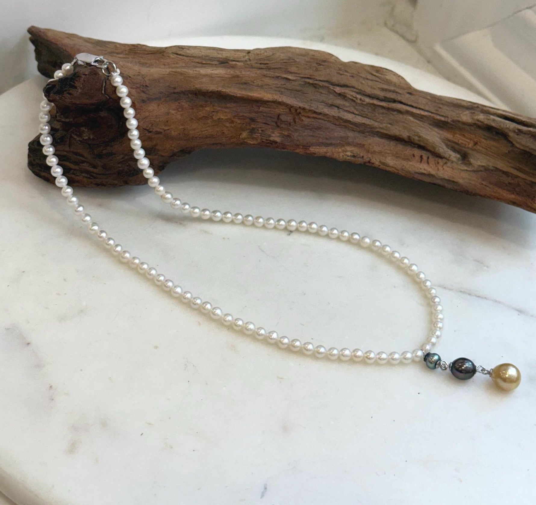 White freshwater pearl strand with green and dark Tahitian pearls and golden South Sea pearl pendant.