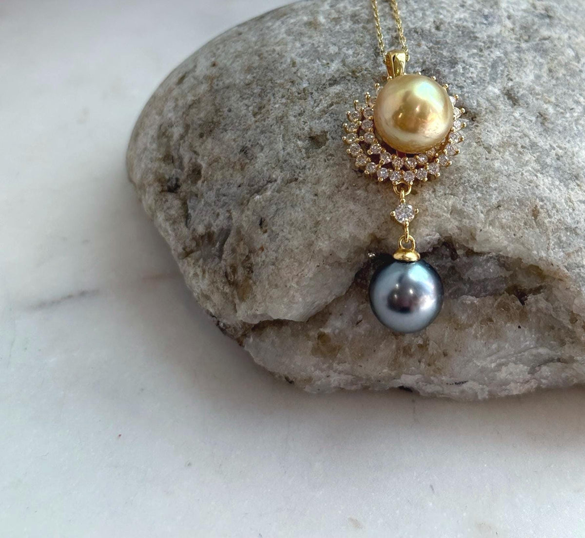 Two premium saltwater pearls in golden and dark Tahitian tones on a minimalist S925 silver setting.