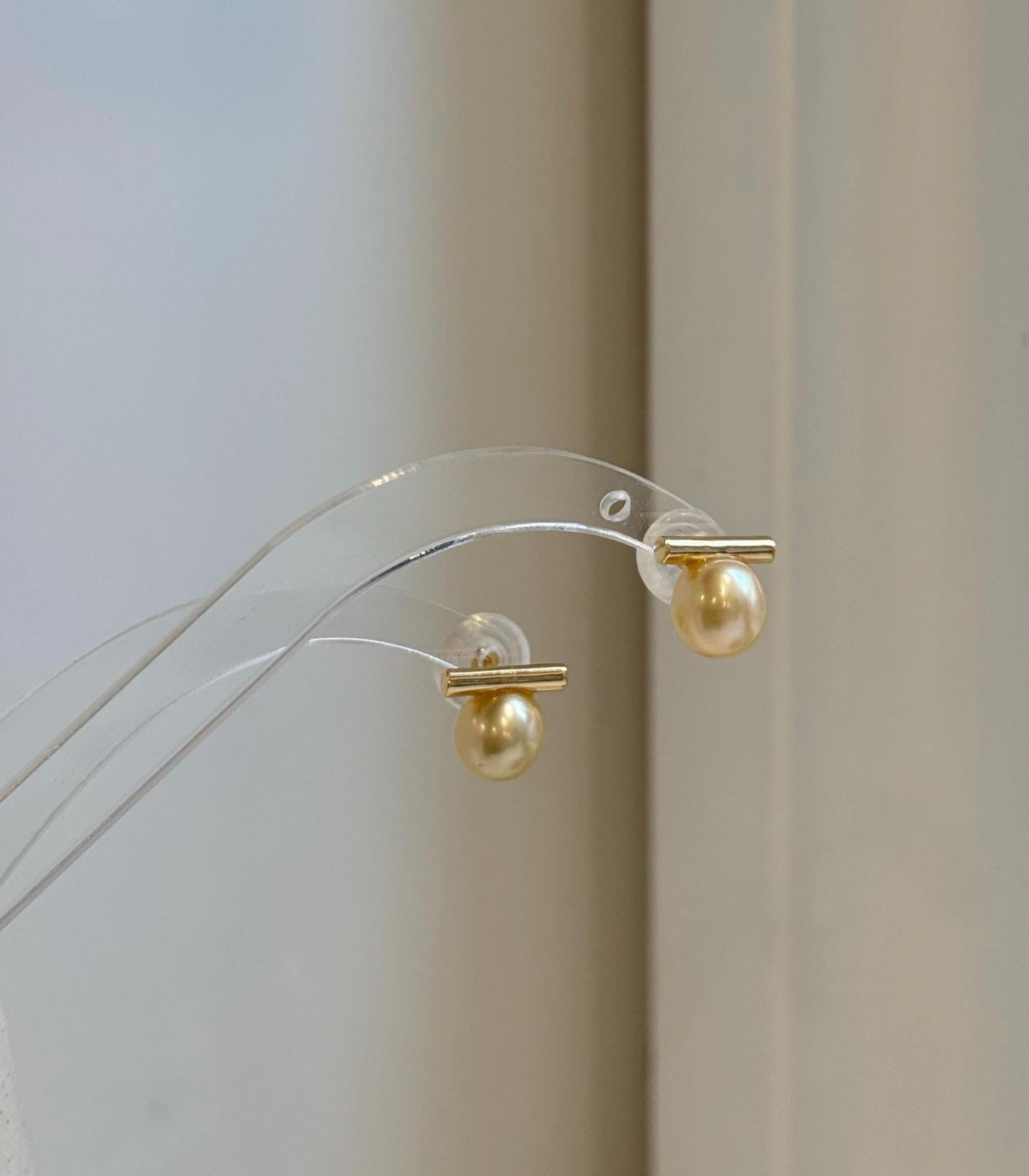 Minimalist 8.8mm golden pearl earrings with beautiful high-luster saltwater pearls.