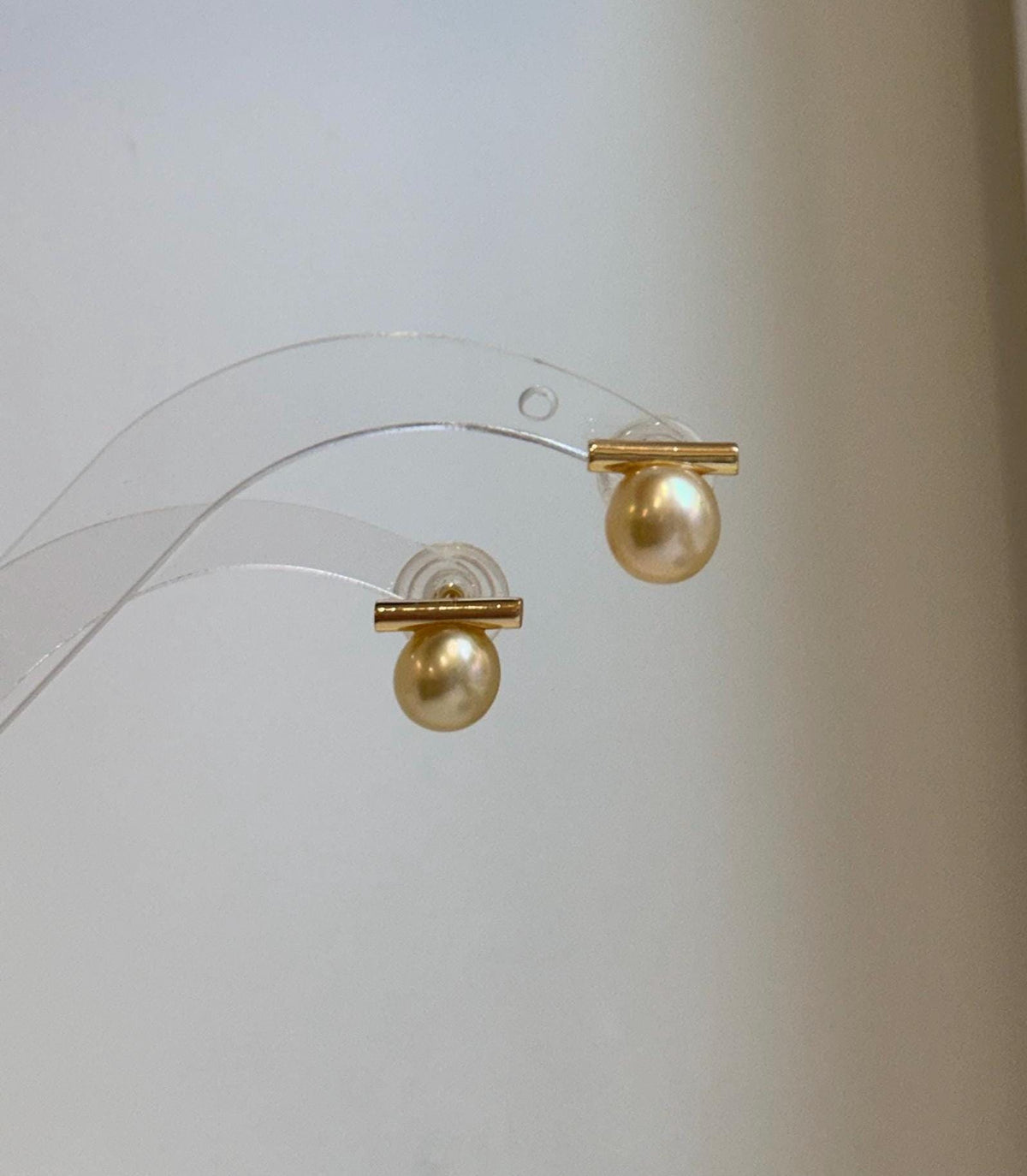 Elegant South Sea golden pearl earrings featuring a unique asymmetrical balanced style.