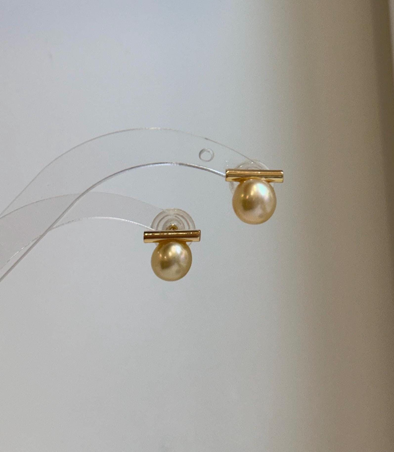 Elegant South Sea golden pearl earrings featuring a unique asymmetrical balanced style.