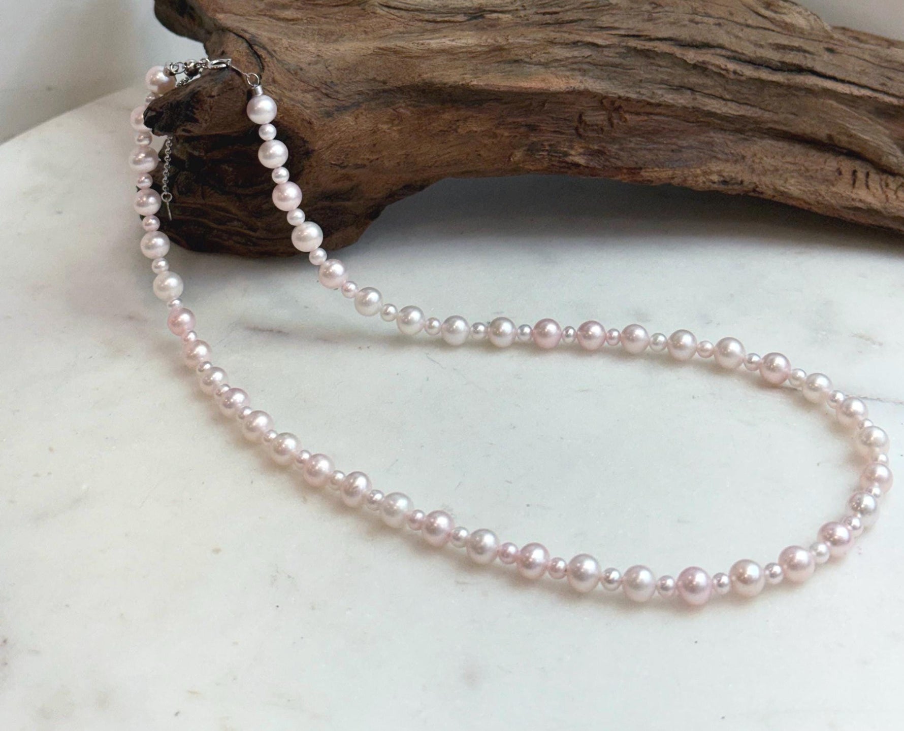 Close-up of genuine pale pink freshwater pearls showing their beautiful natural color and mirror-like shine.