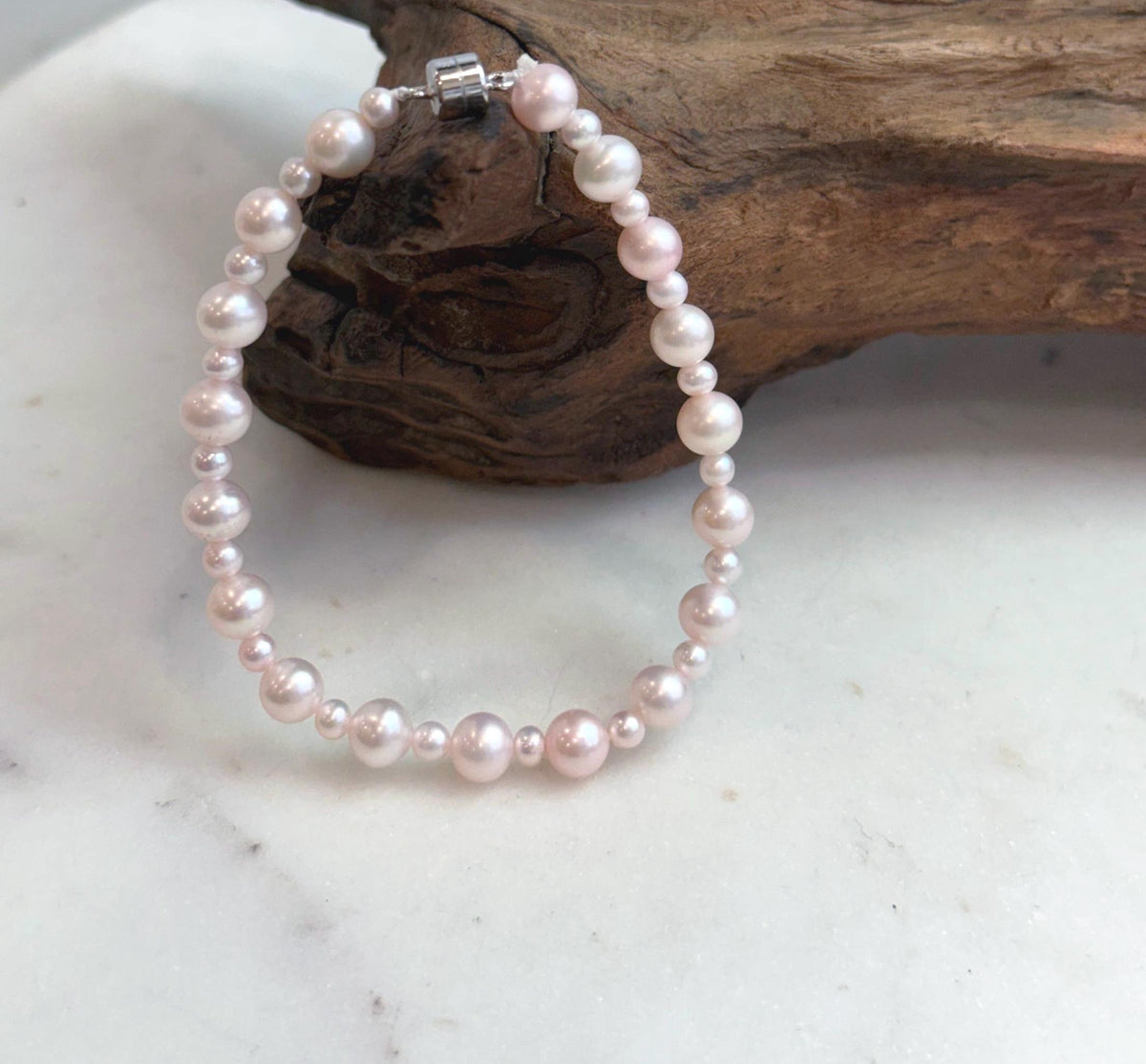 Close-up of genuine pale pink freshwater pearls showing their natural soft pink color and beautiful shine.