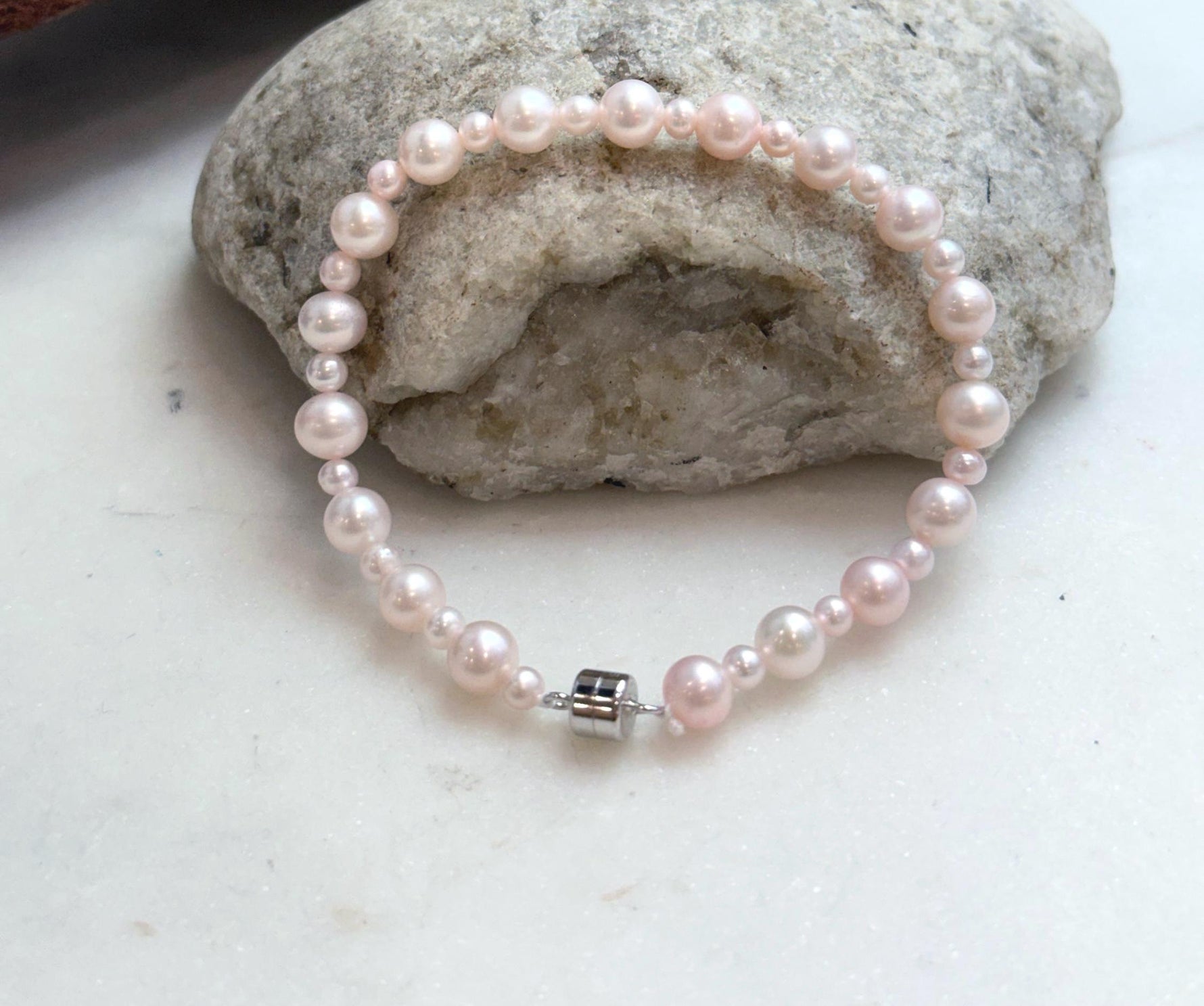 Delicate pale pink pearl bracelet with lustrous genuine freshwater pearls for elegant everyday wear.