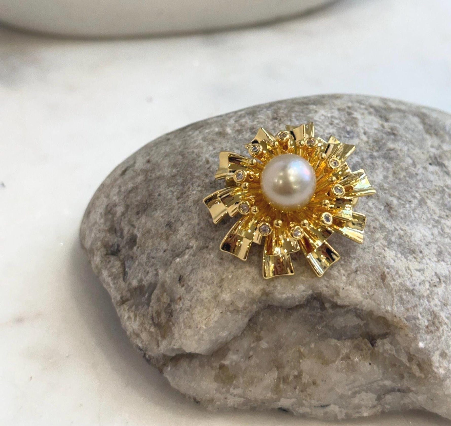 Elegant flower brooch featuring a natural ivory golden South Sea pearl.