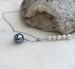 Elegant Y-shaped pearl necklace featuring a Tahitian pearl and luminous white freshwater pearls.