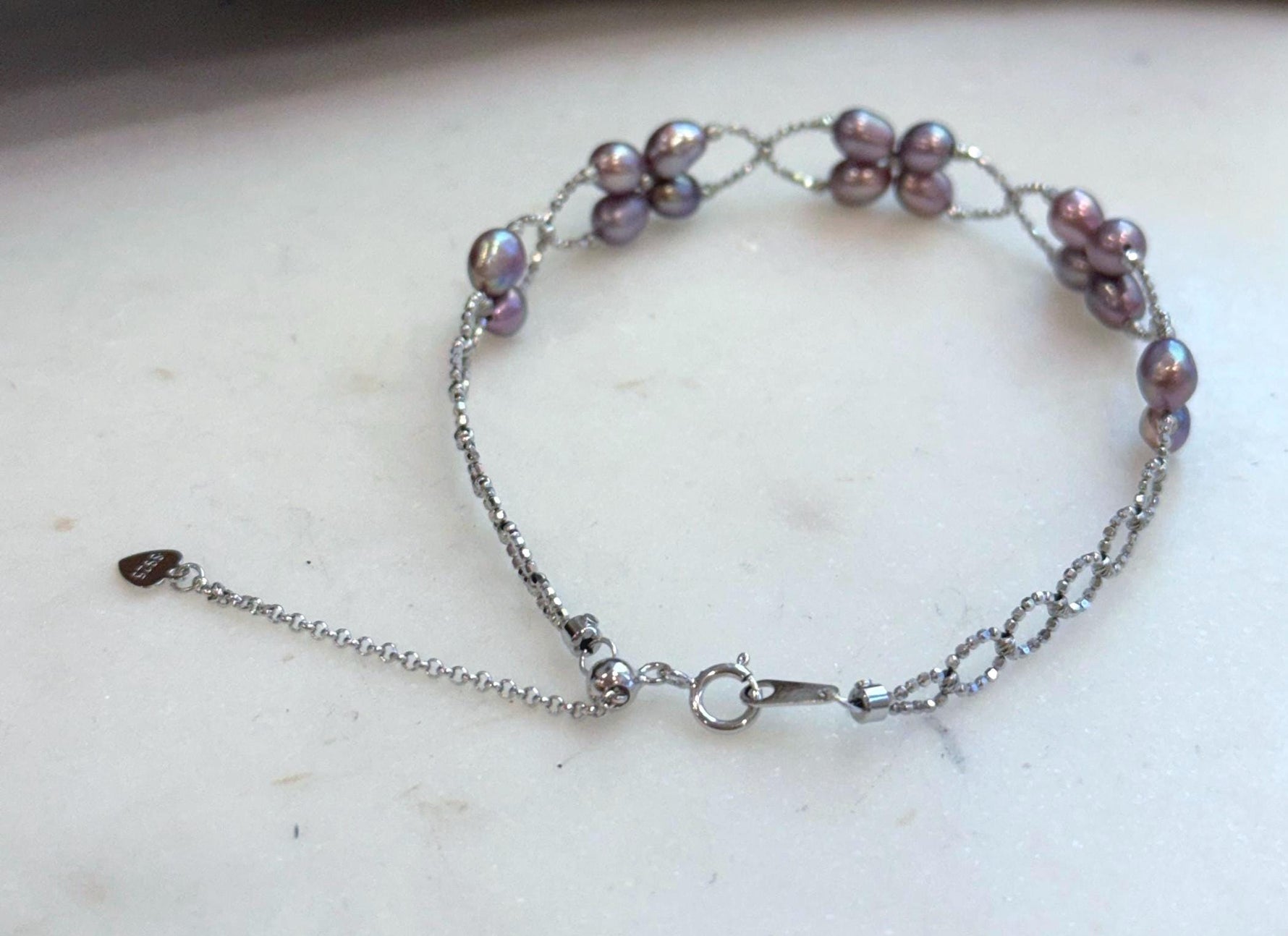 Delicate sterling silver bracelet adorned with 16 genuine Keshi pearls.