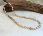Close-up of peach rose gold Keshi pearls showing intense mirror-like luster and beautiful color variations.