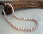 Elegant 17.8-inch genuine pearl necklace with 9–10mm pale pink pearls and extreme mirror luster.