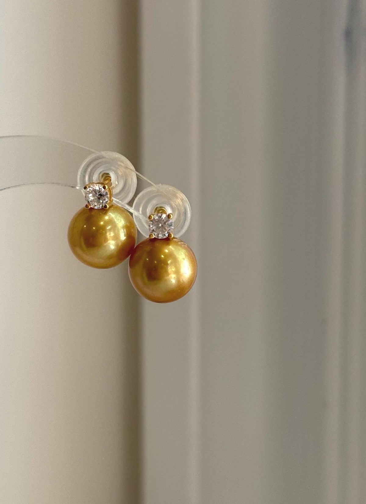 Elegant golden freshwater pearl stud earrings with large 11.3mm Edison pearls and sterling silver settings.