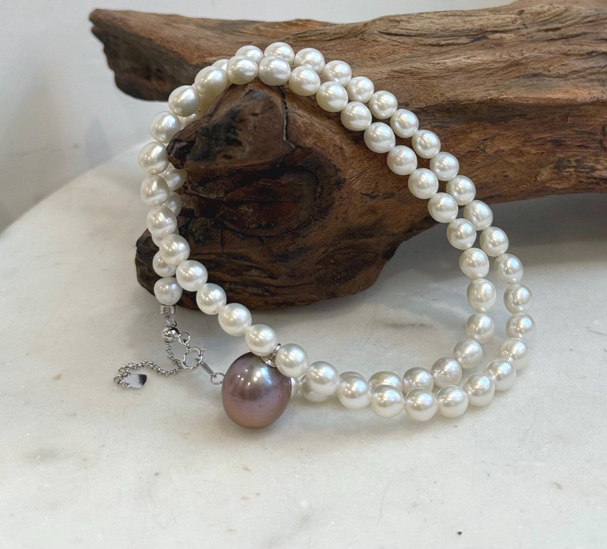 Classic white pearl strand accented with a statement purple Edison pearl.