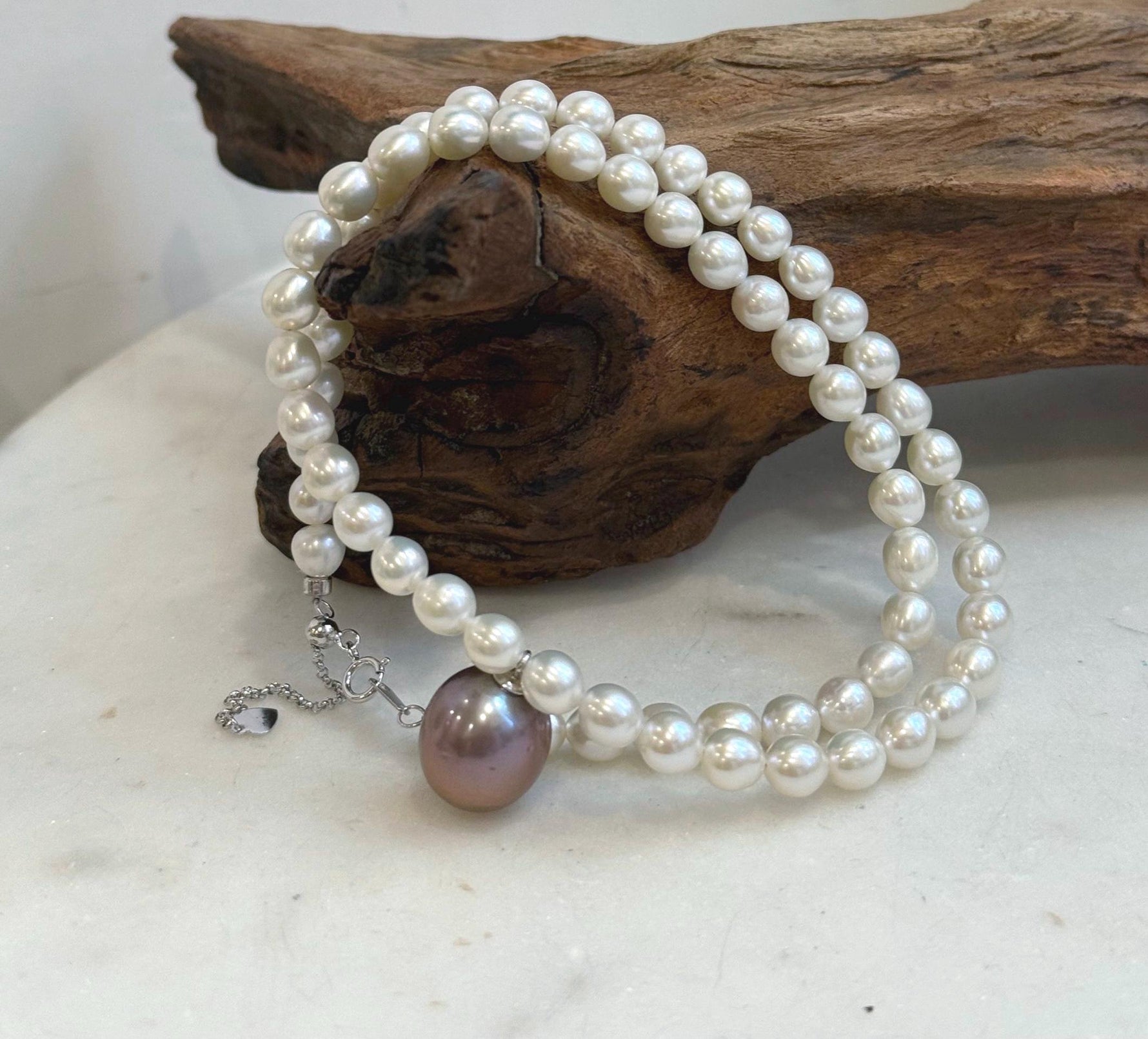Classic white pearl strand accented with a statement purple Edison pearl.