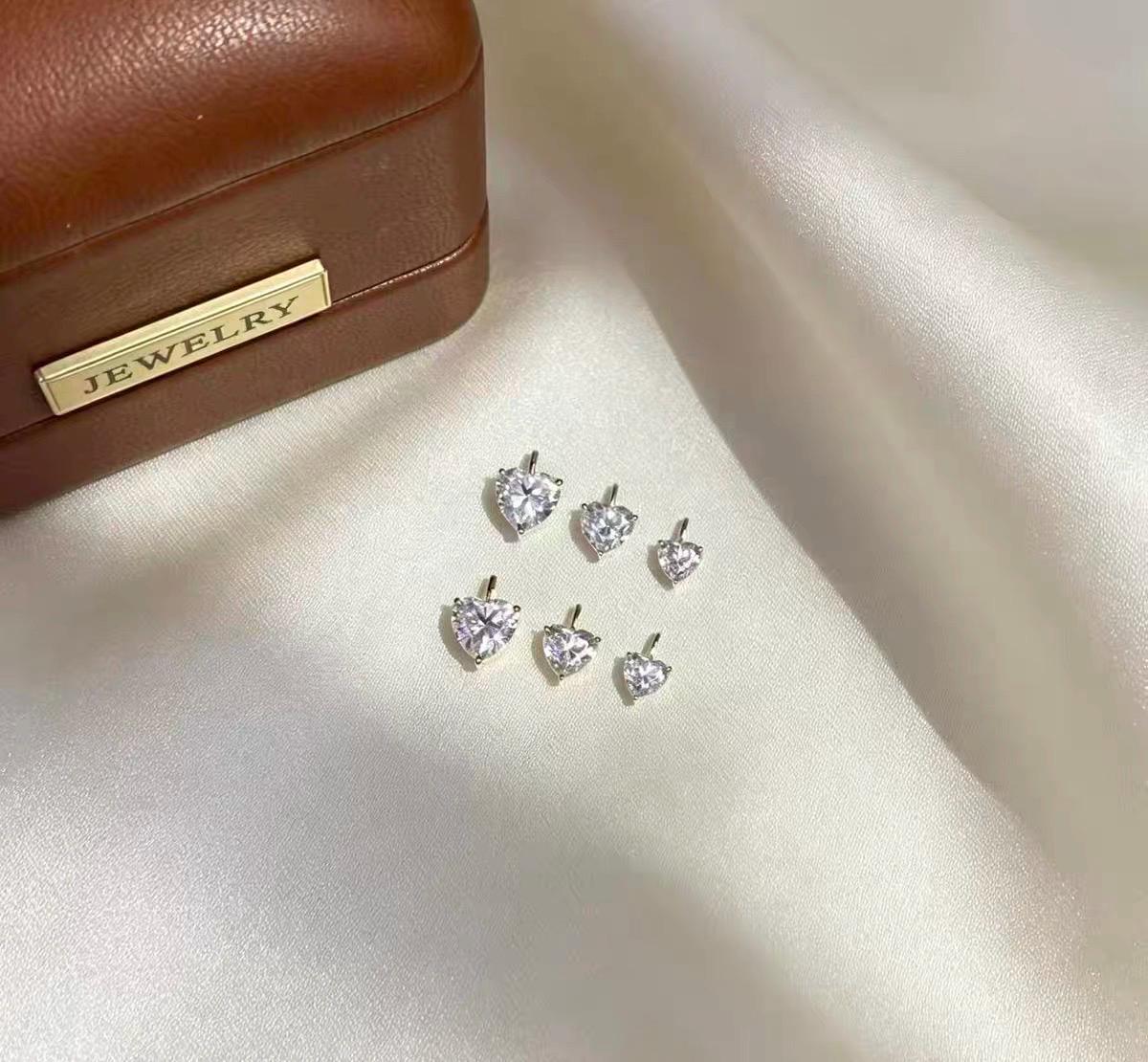 Dainty heart shaped moissanite pendant charm available in yellow gold and white gold styles.