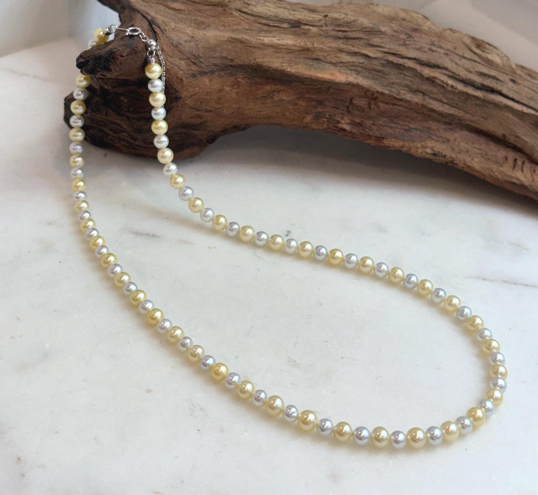 Close-up of 4.3–5.5mm freshwater pearls showing their radiant golden silver colors.