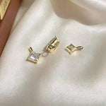 Diamond shaped princess cut moissanite charm in solid 18K white gold with brilliant clear sparkle.