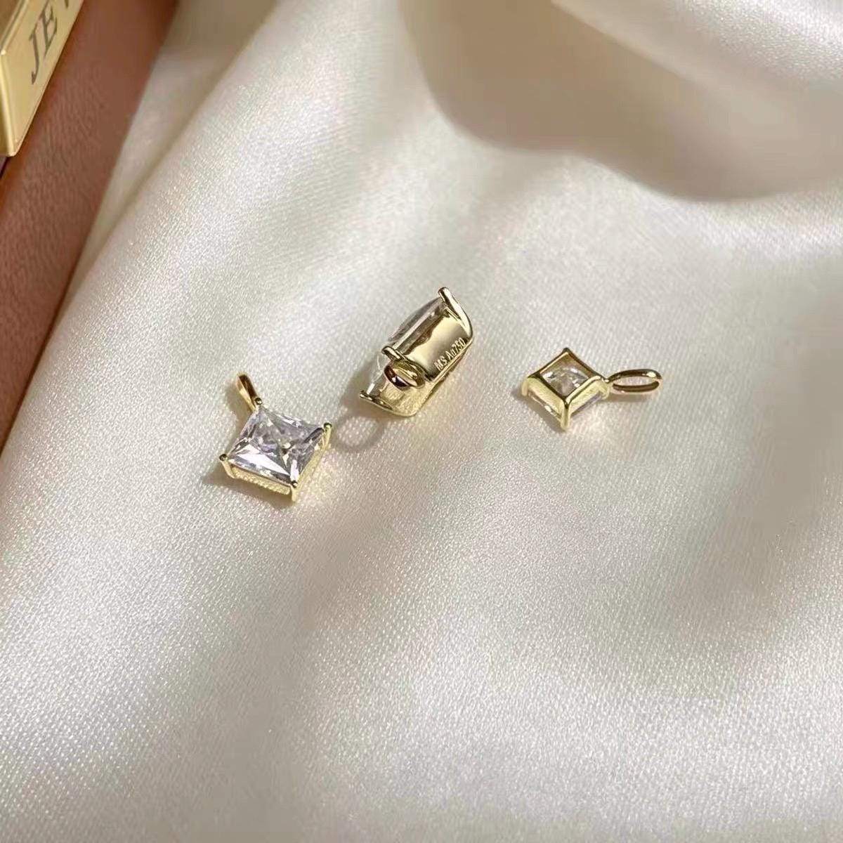Diamond shaped princess cut moissanite charm in solid 18K white gold with brilliant clear sparkle.