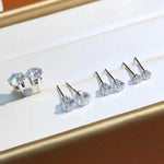 Fine jewelry moissanite earrings featuring brilliant round stones set in classic six-prong solid 18K gold settings.