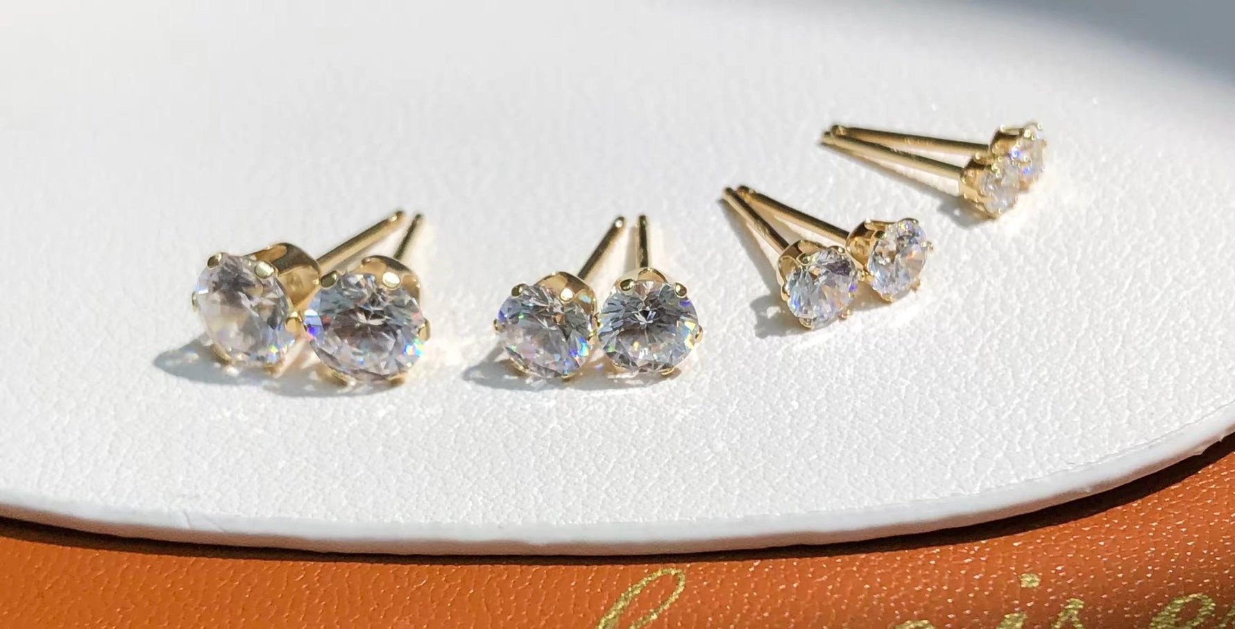 Close-up of brilliant round moissanite earrings crafted in Au750 solid 18K yellow gold with secure 6-prong settings.