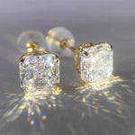 Macro view of 4-prong Asscher cut moissanite stud earrings showing detailed solid gold craftsmanship.