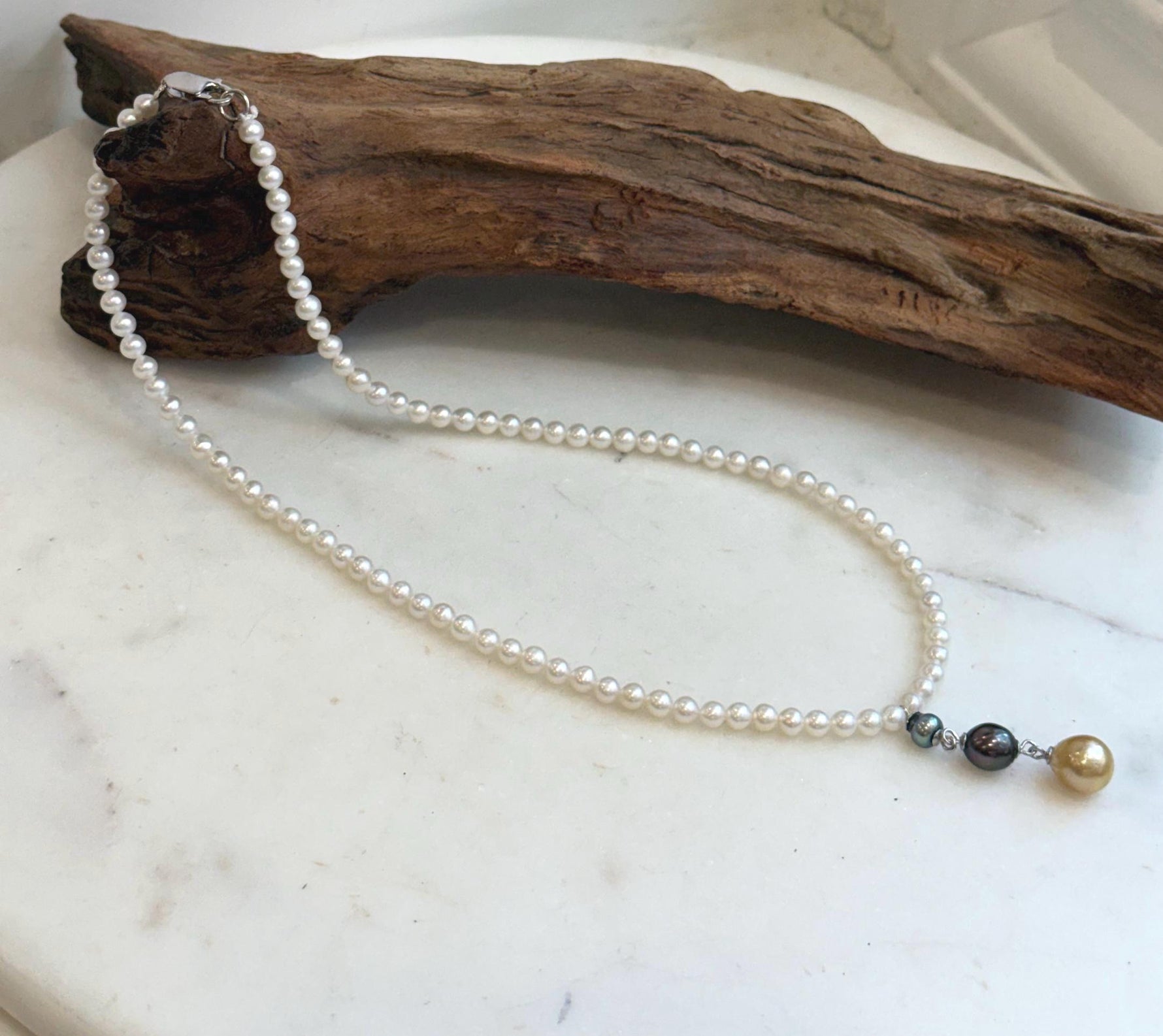 Elegant pearl necklace set with white freshwater pearls and Tahitian and South Sea pearl accents.