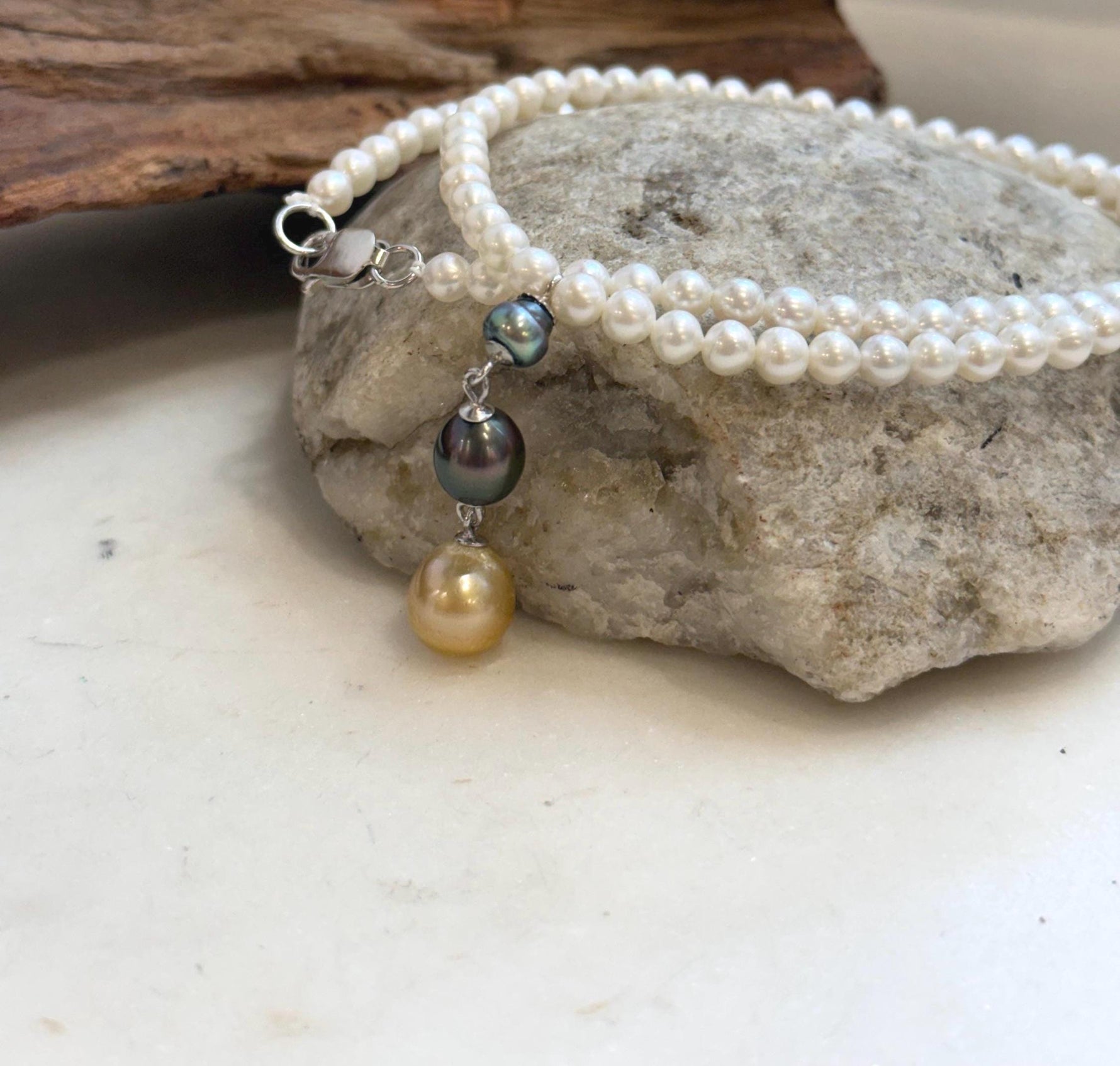 Luxury multicolor pearl drop necklace featuring green, dark and golden pearl tones.