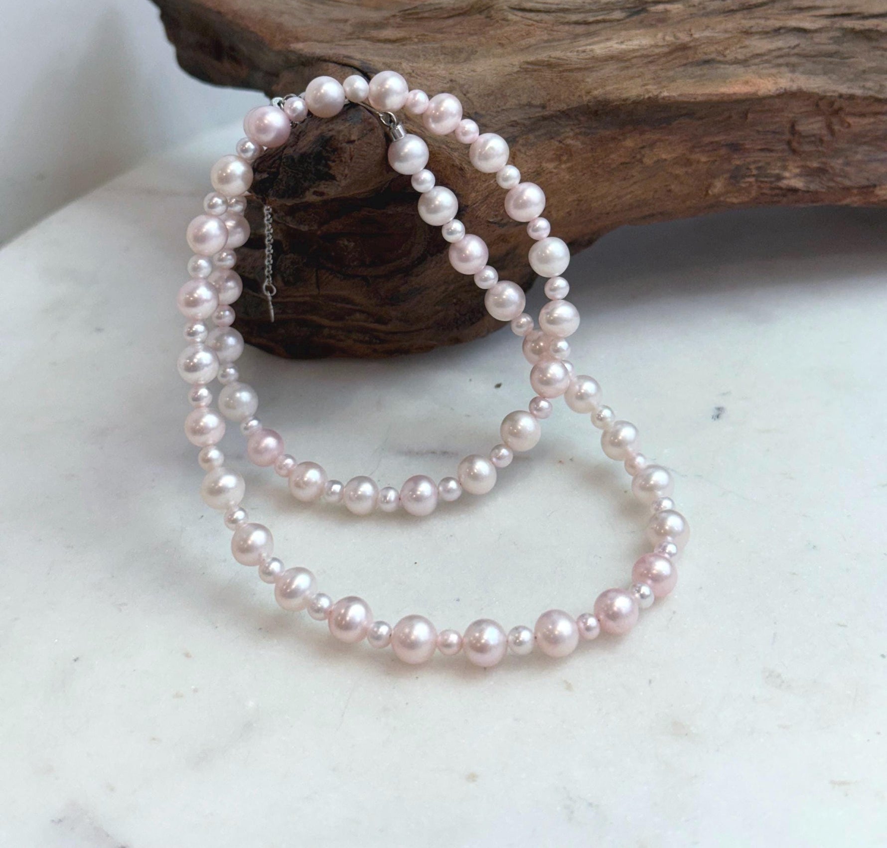 Natural freshwater pearl necklace in a soft pale pink tone with bright mirror luster.
