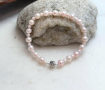 Elegant pale pink freshwater pearl bracelet with luminous mirror luster and delicate graduated design.