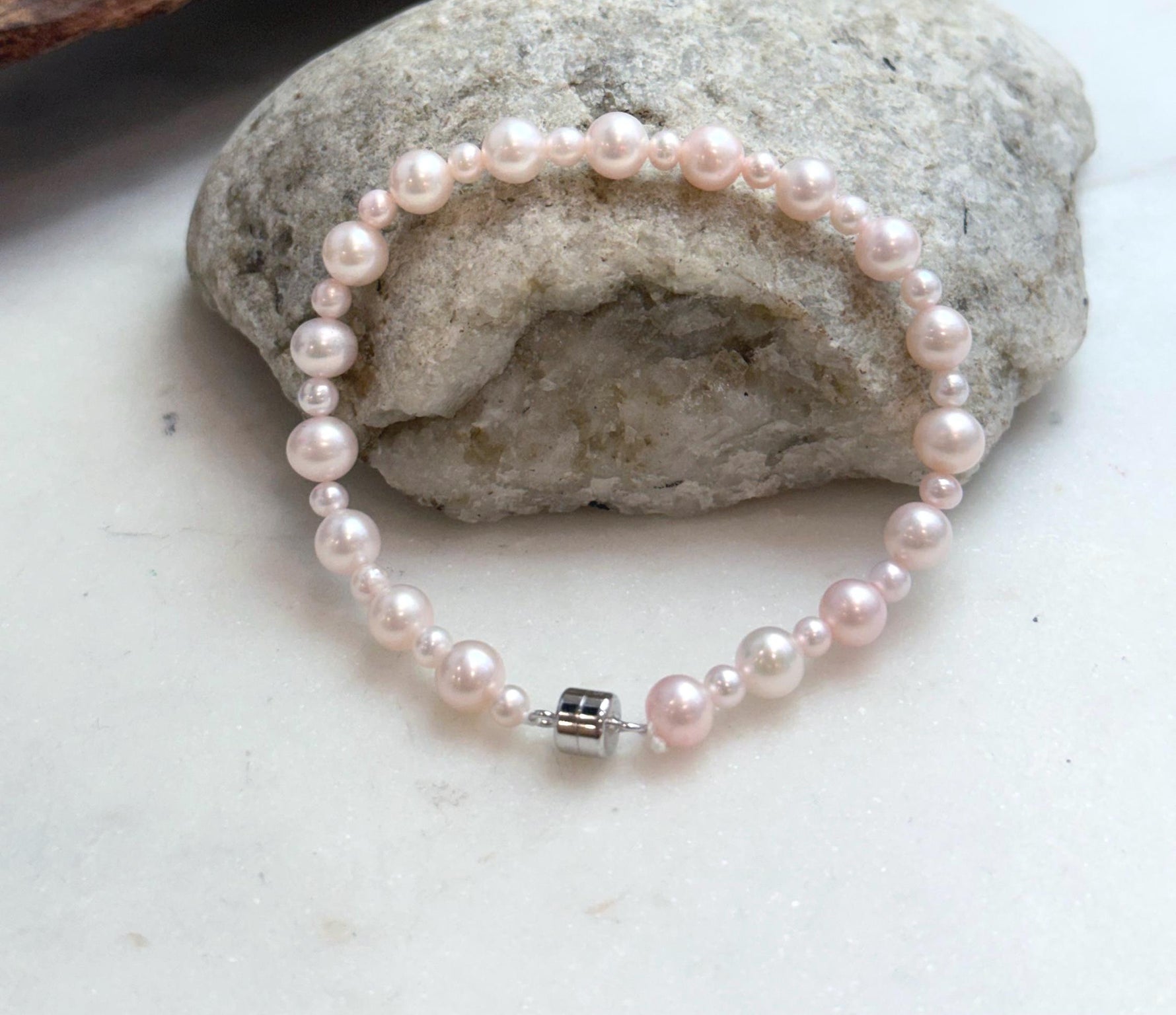 Elegant pale pink freshwater pearl bracelet with luminous mirror luster and delicate graduated design.